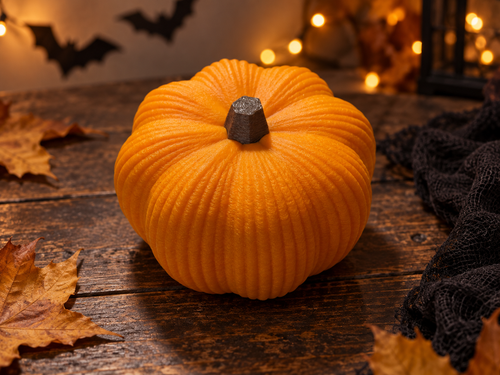 AI-styled Halloween scene showing the ribbed orange 3D printed pumpkin with a dark brown stem, autumn leaves and bat decorations