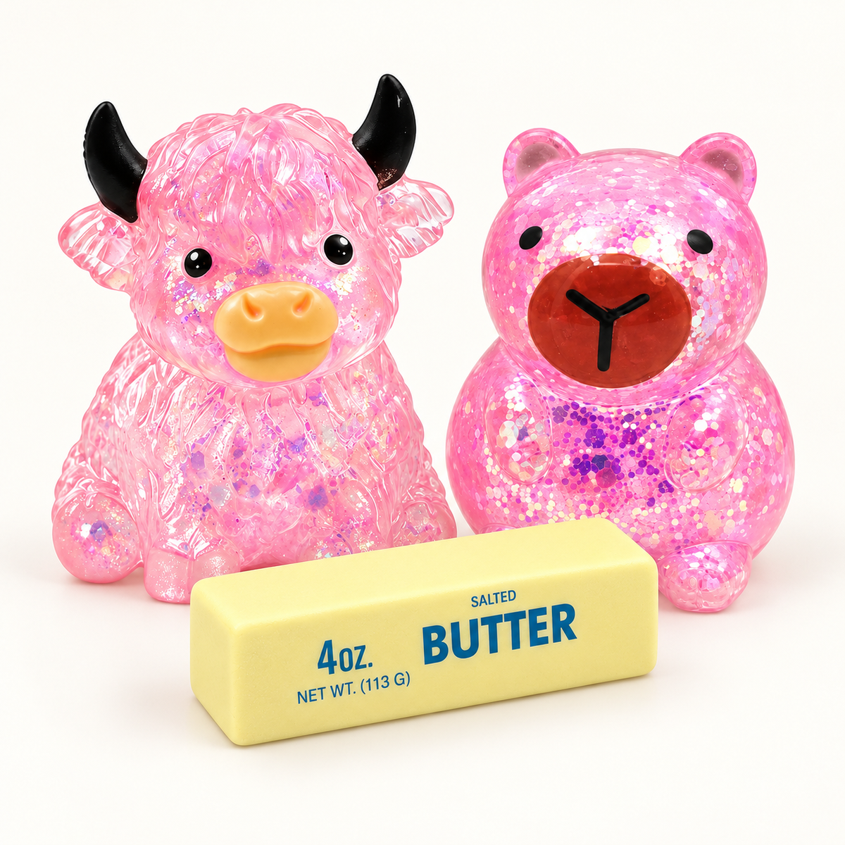 Three-piece squishy bundle with glitter cow, glitter capybara and butter stick; colors shown are examples